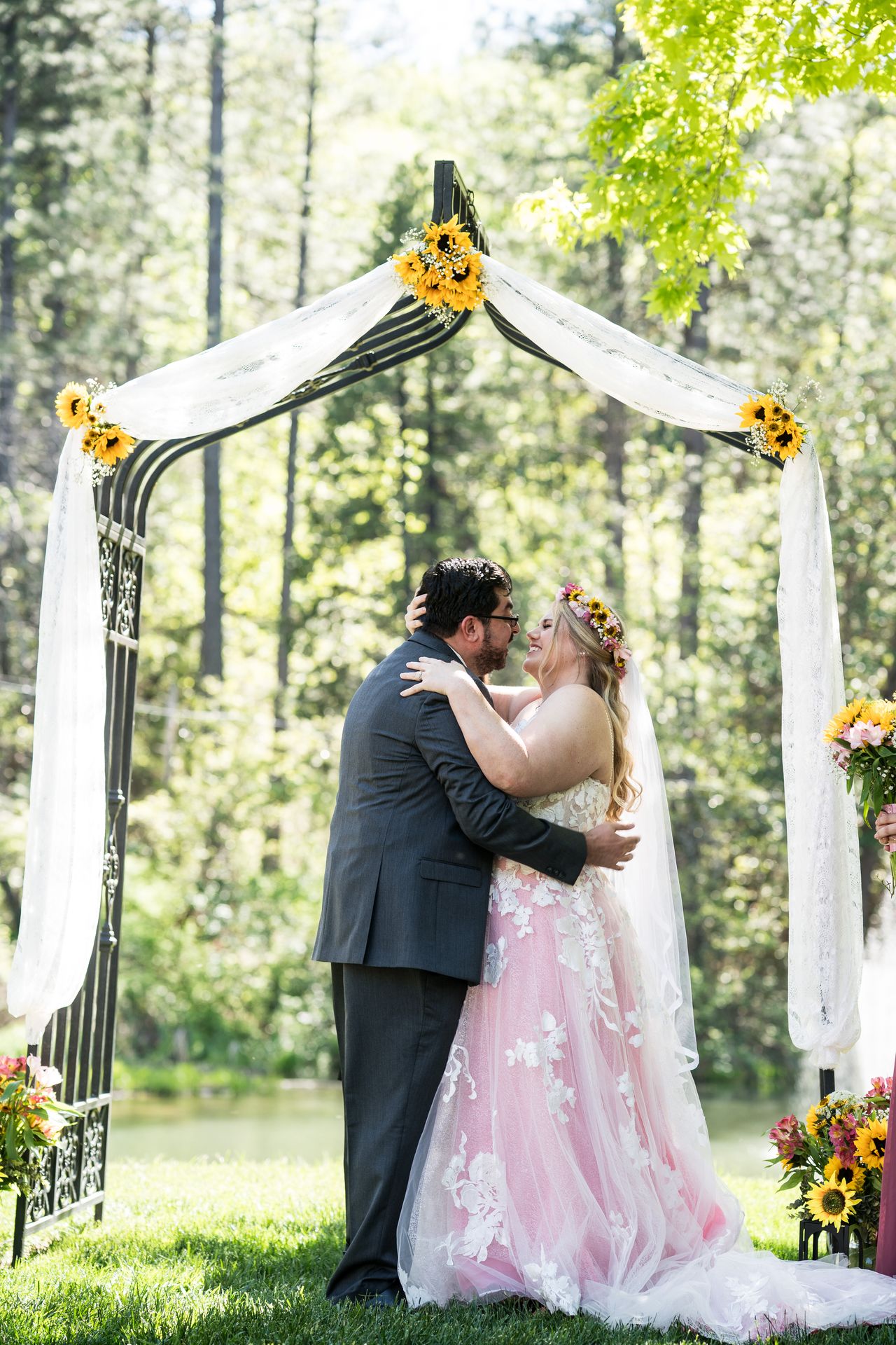 Abney and Chris hold each other under the sunflower arbor at the end of the ceremony