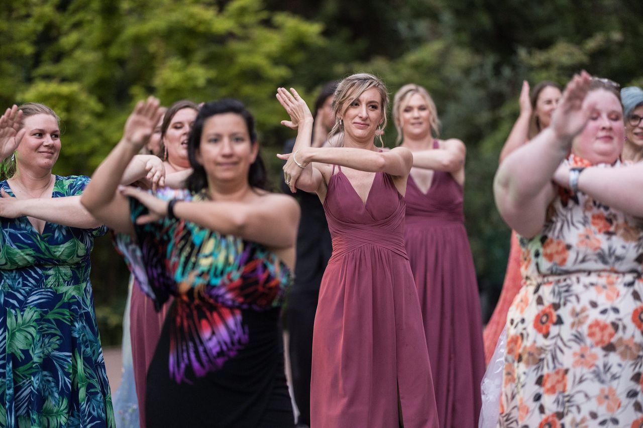 Guests move through a group dance together with their arms crossed in front of them