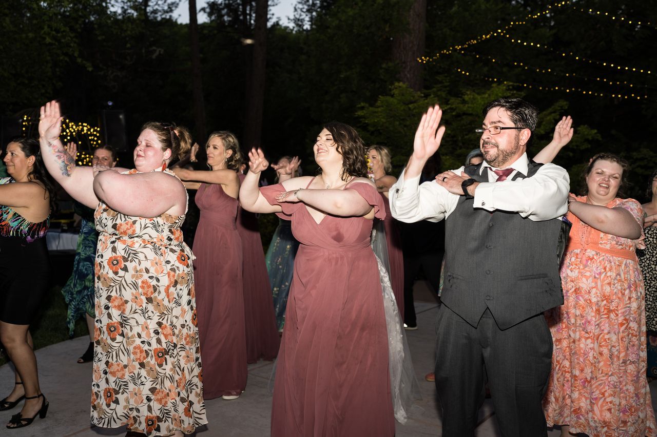 Chris and the guests hold their hands up during a group dance after dark