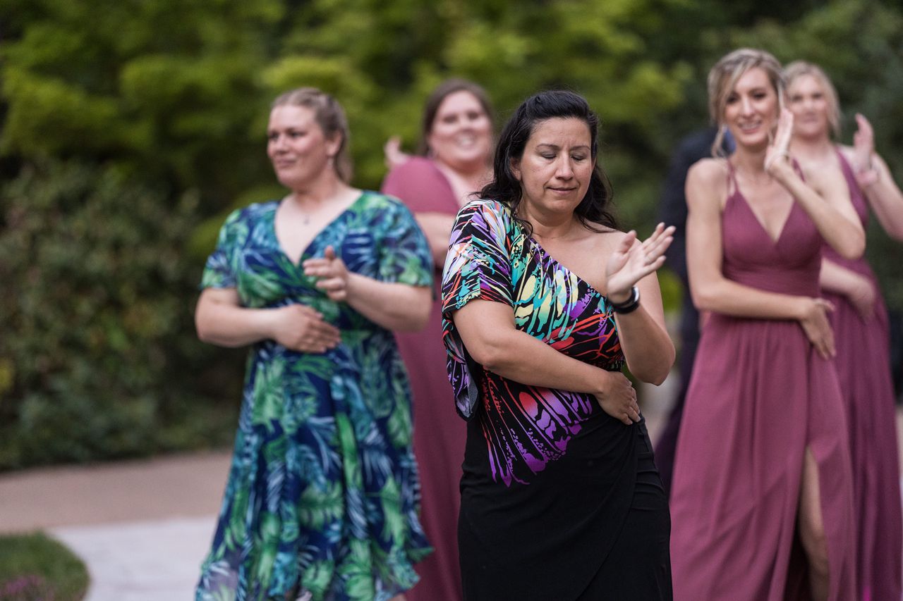 Guests follow the steps of a group dance on the patio