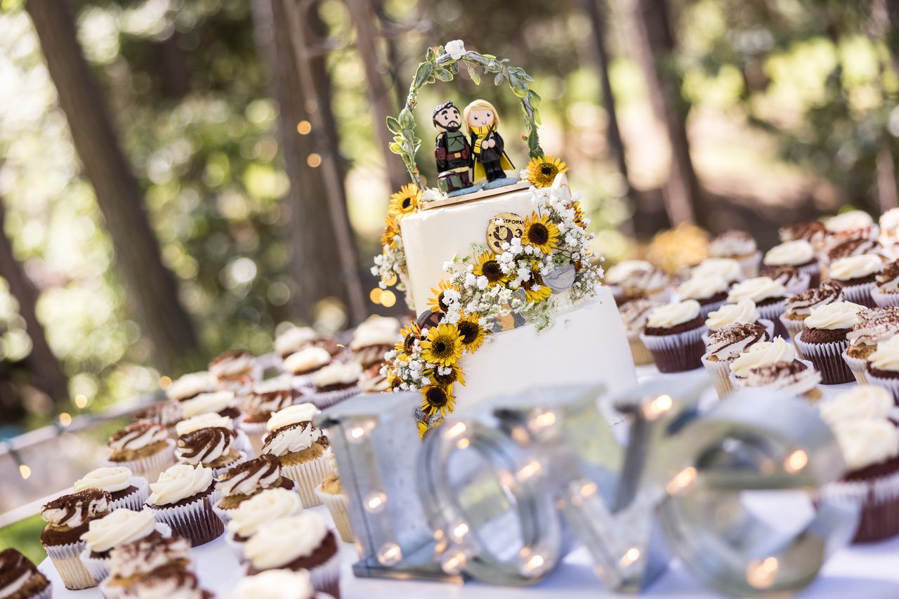 Metal letters spelling LOVE on the cupcake table with the wedding cake behind them