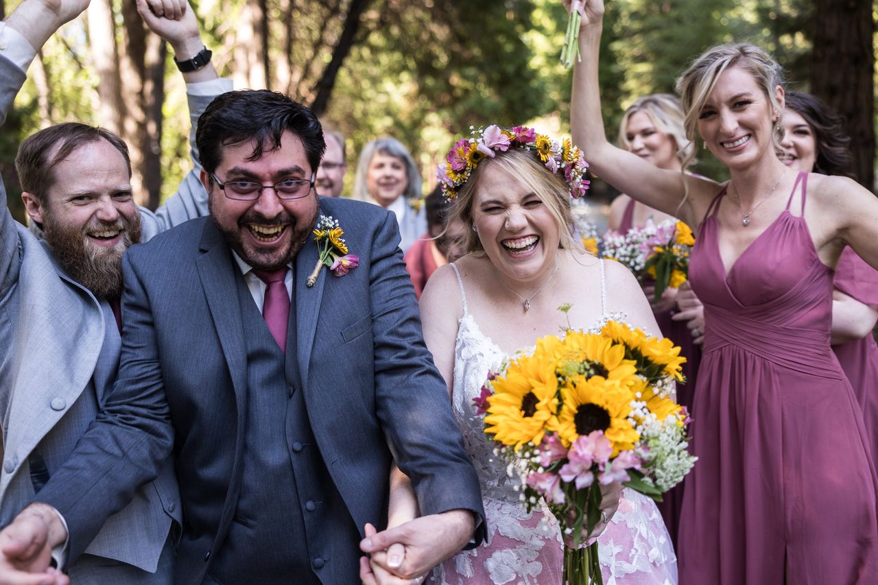 The wedding party crowds in around Abney and Chris, everyone laughing