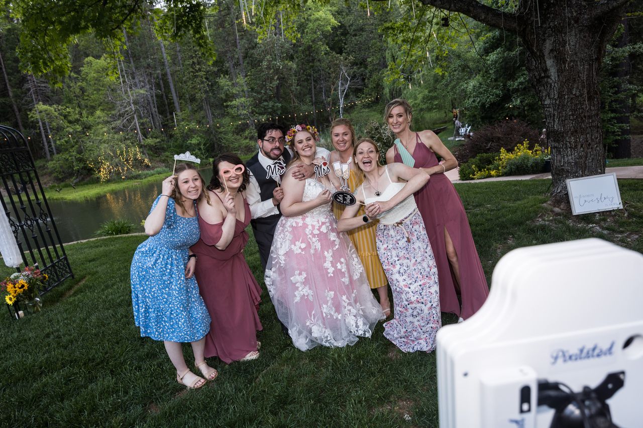 Abney, Chris and their friends pose with props at the photo booth