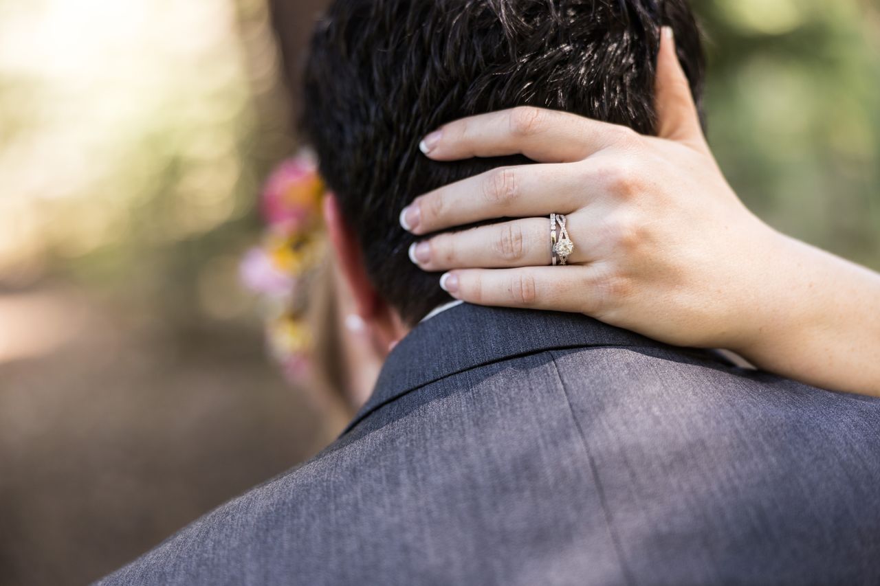 Abney's hand, wearing her wedding ring, rests on the back of Chris's neck