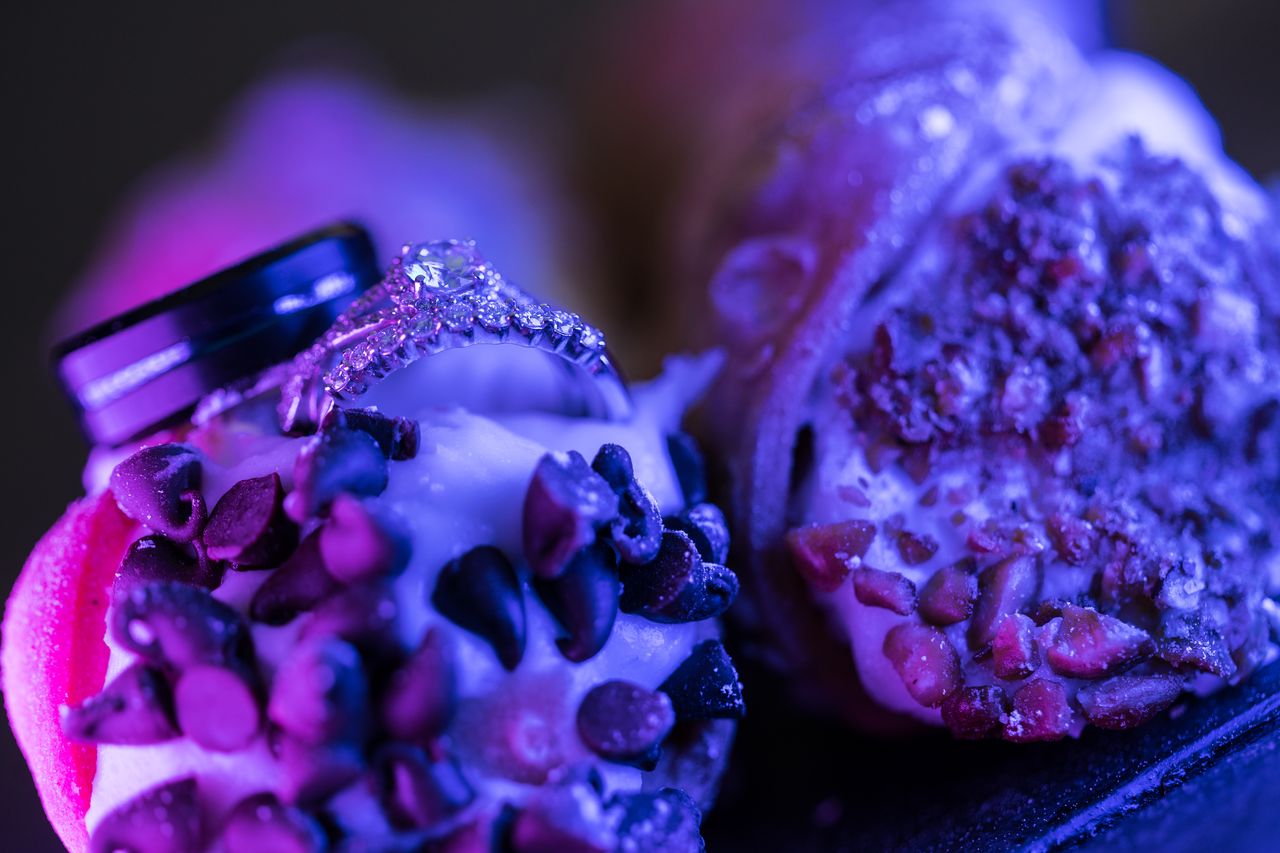 The engagement ring and both wedding bands resting on a cannoli dipped in chocolate chips