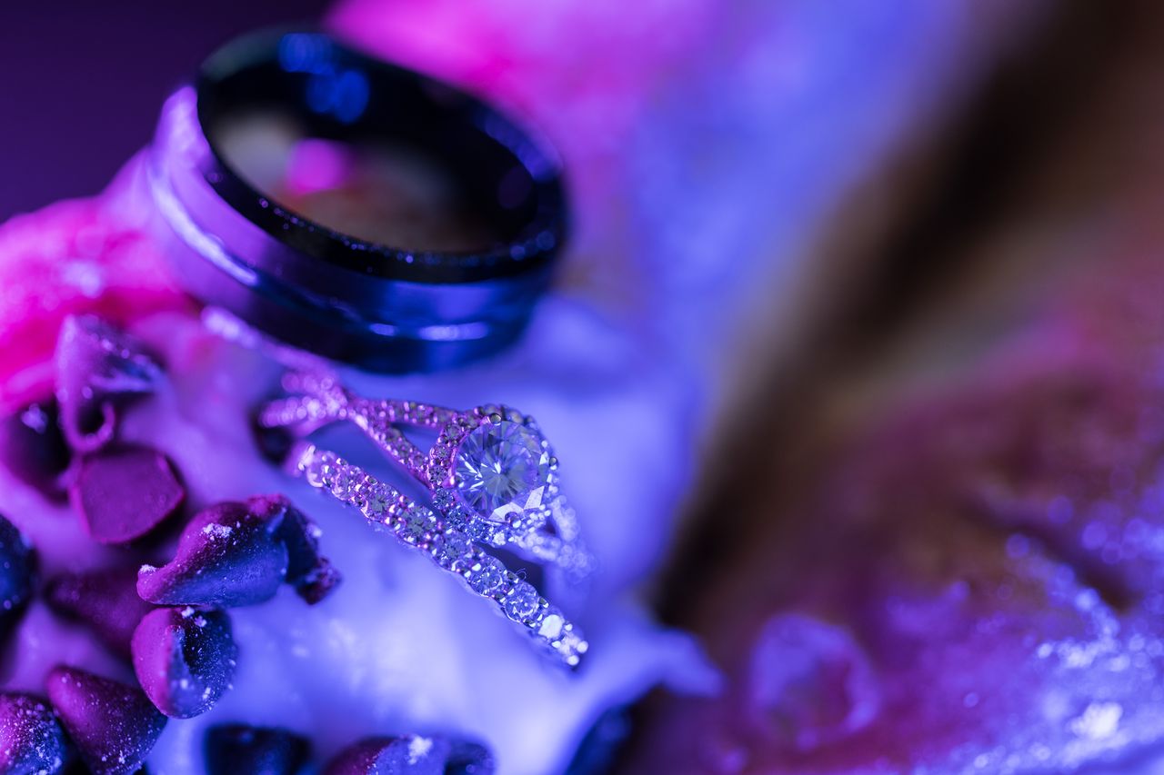 The engagement ring and wedding bands resting on a cannoli, seen from above