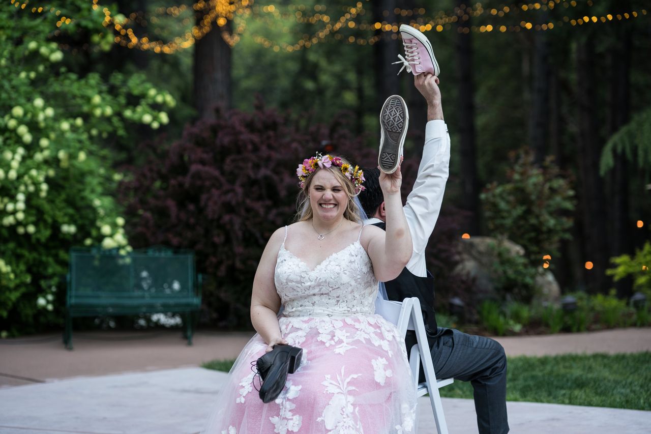 Abney laughs during the shoe game, holding up a pink sneaker beneath the string lights