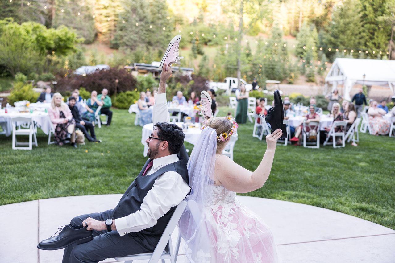 Abney and Chris play the shoe game back to back on the patio while guests look on from the lawn