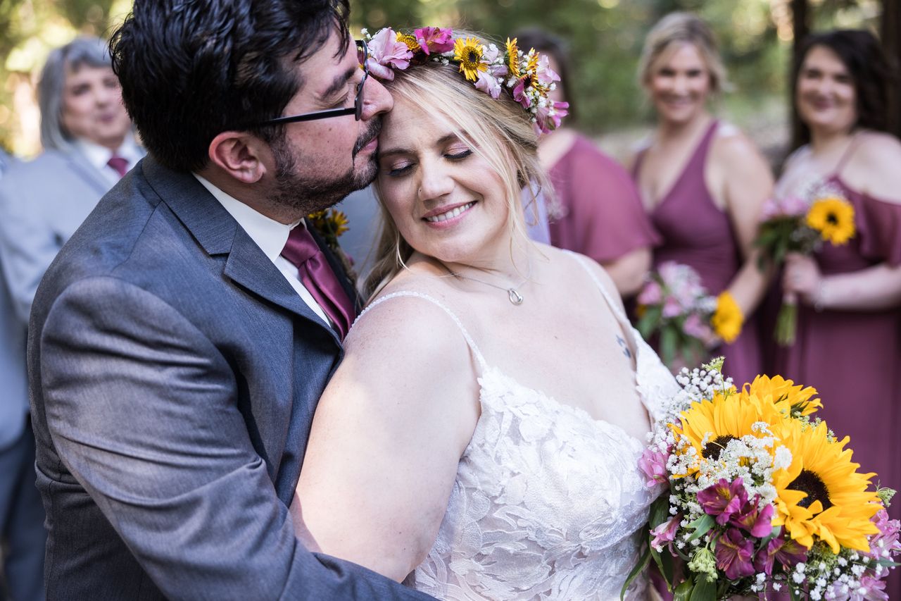 Chris kisses Abney on the temple while she smiles with her eyes closed