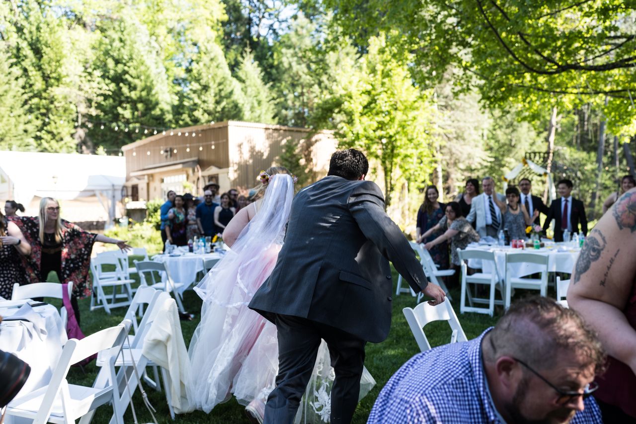 Abney and Chris make their way between the reception tables as guests look on
