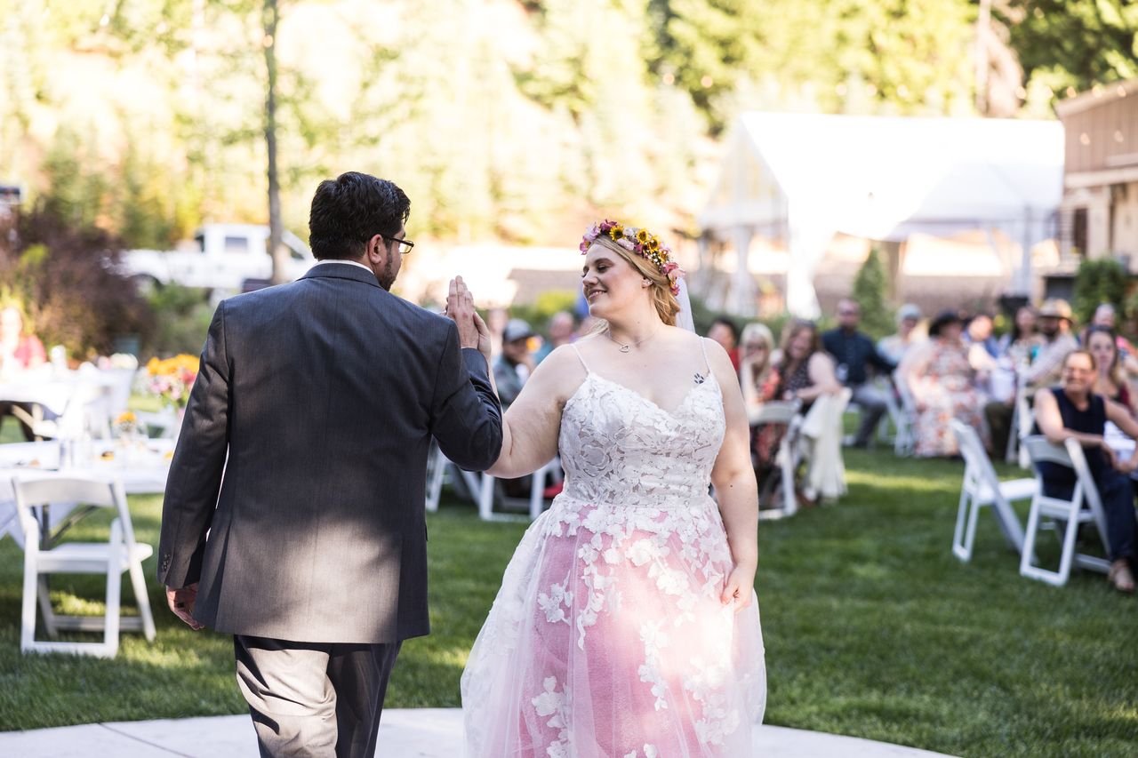 Abney smiles as she and Chris walk onto the patio for their first dance