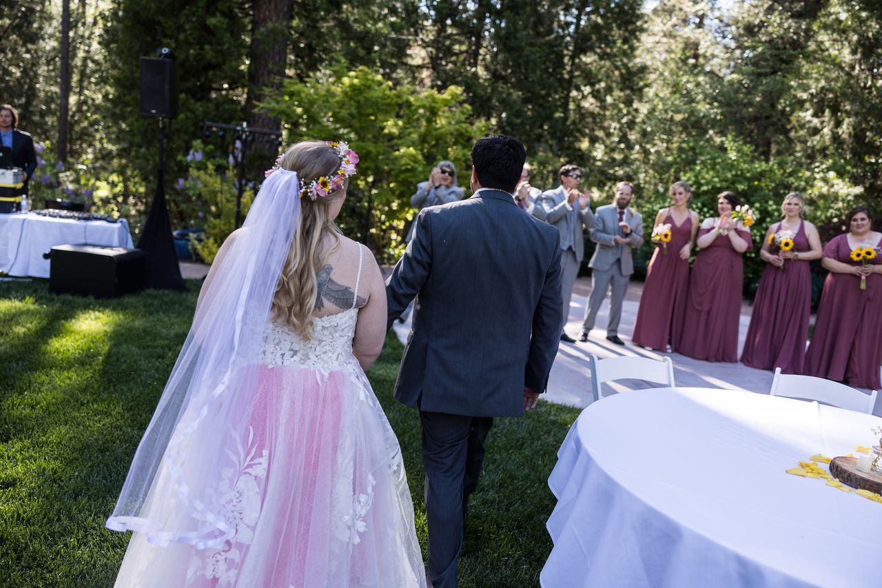 Abney and Chris walk toward the reception lawn while their wedding party waits