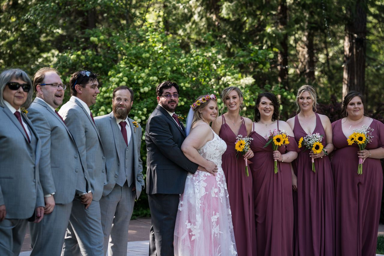 The whole wedding party stands in a row with Abney and Chris in the center