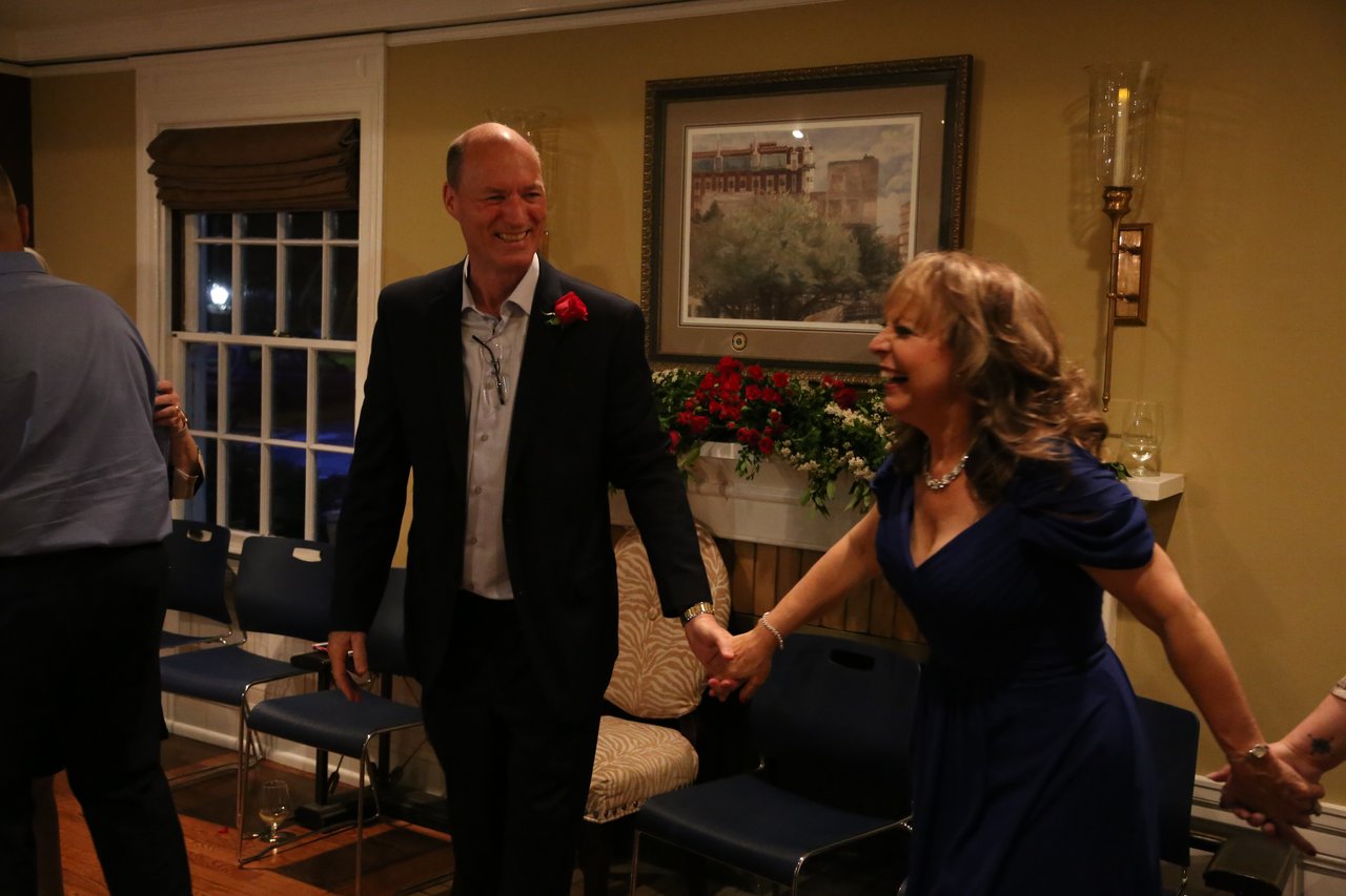 Alexanne and Tim dance hand in hand across the floor