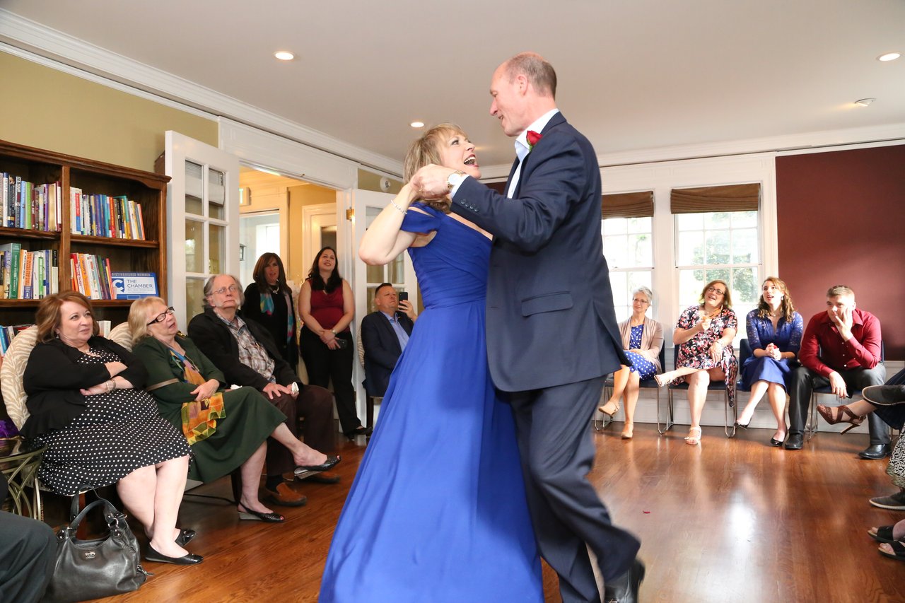 Alexanne and Tim dance in the middle of the room with guests seated all around