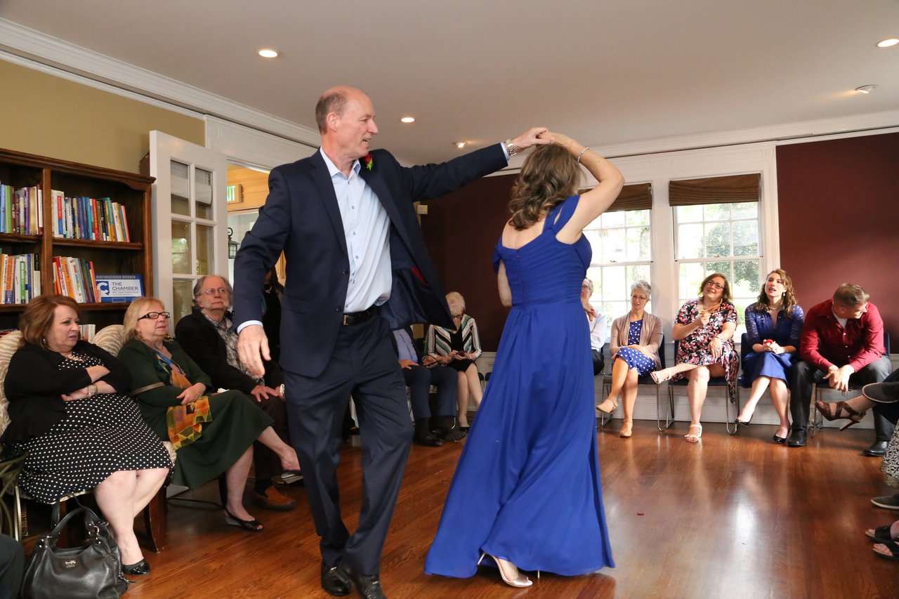 Tim twirls Alexanne across the wood floor