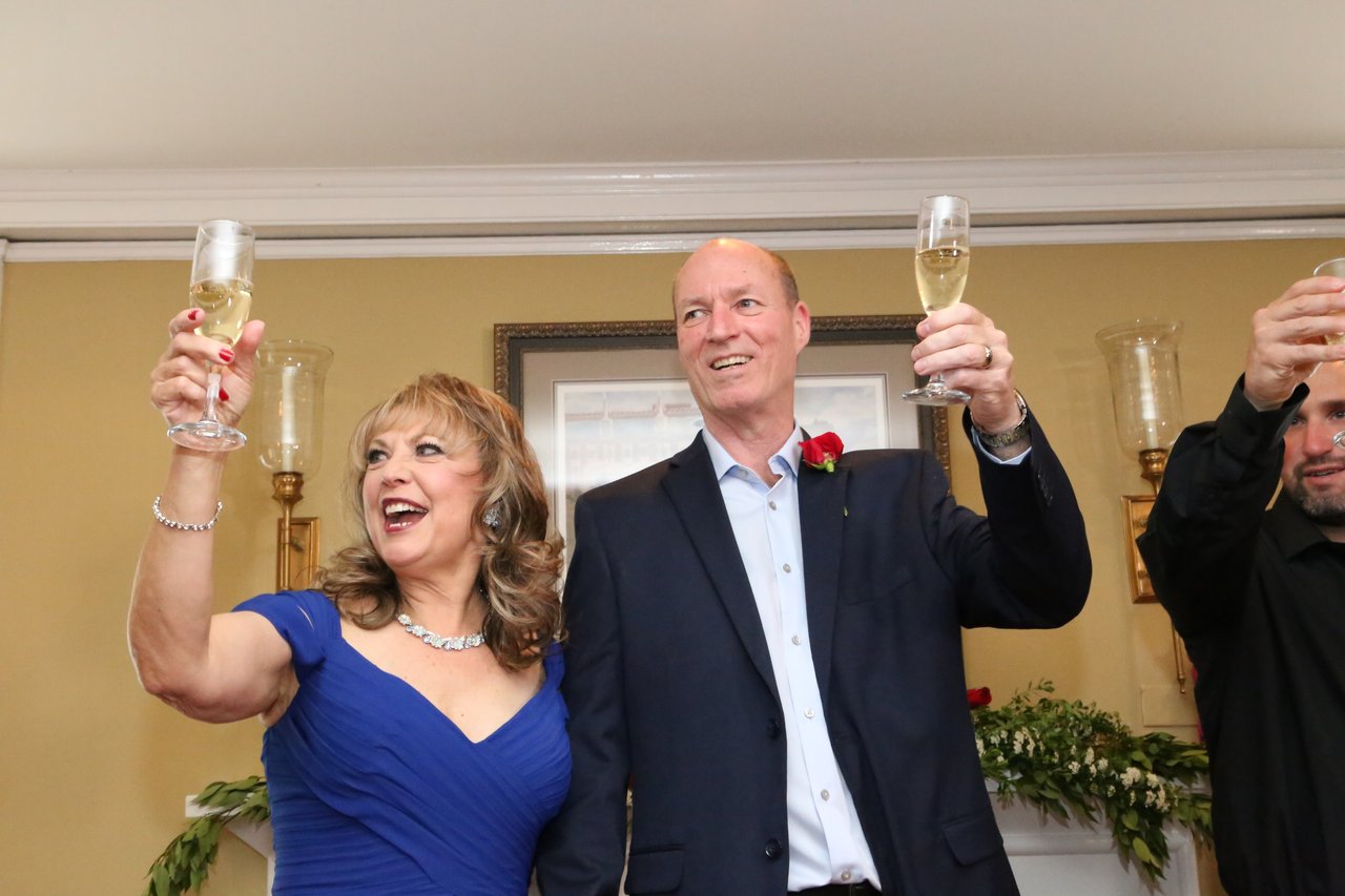 Alexanne and Tim raise their champagne glasses high for a toast
