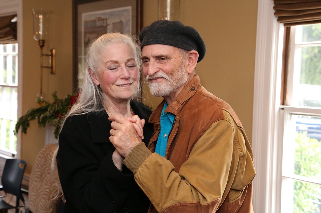 Two guests share a slow dance by the window