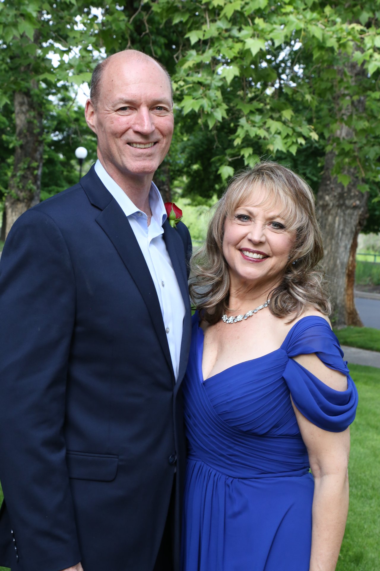 Tim and Alexanne pose together under the trees outside