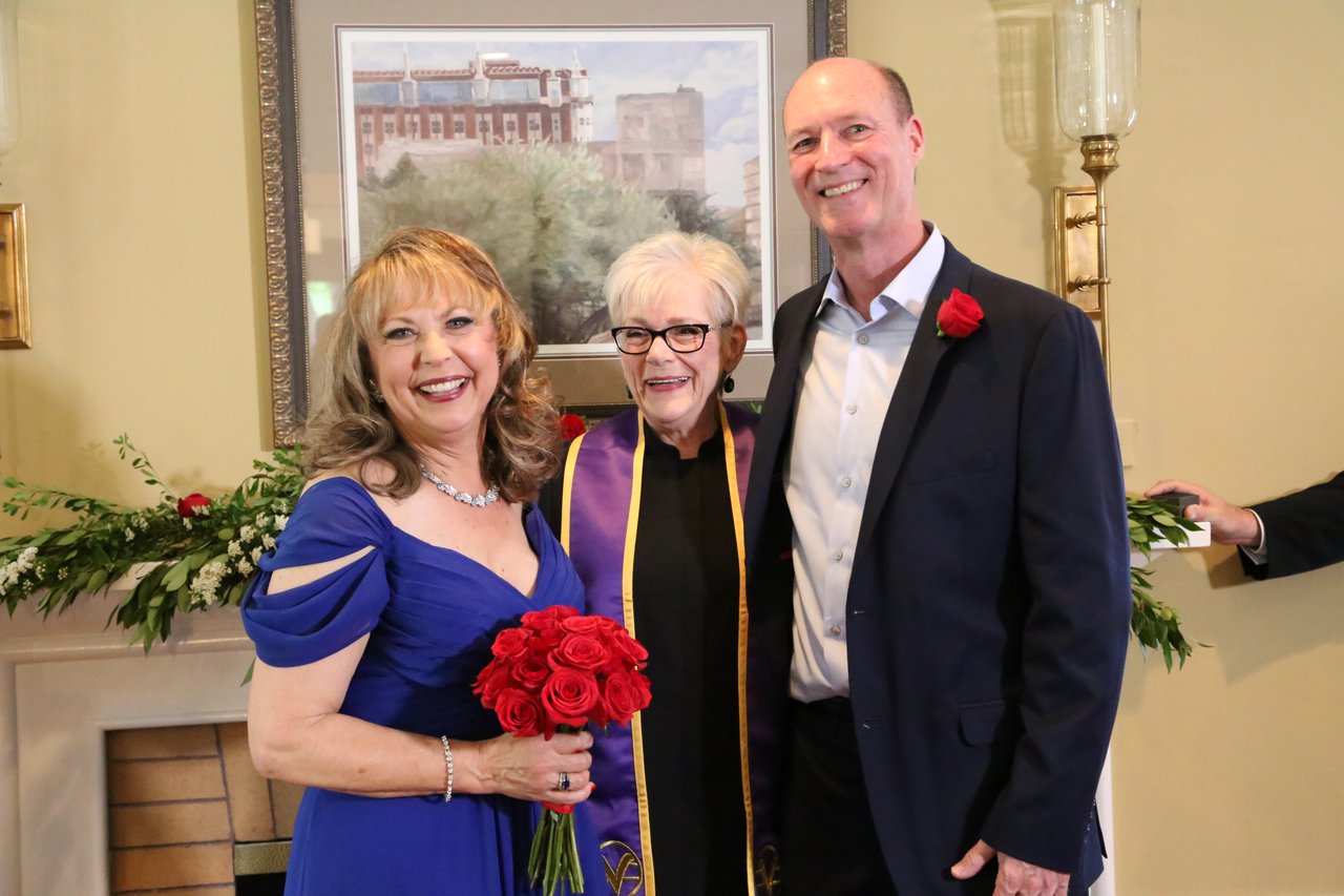 Alexanne and Tim smile with their officiant after the ceremony