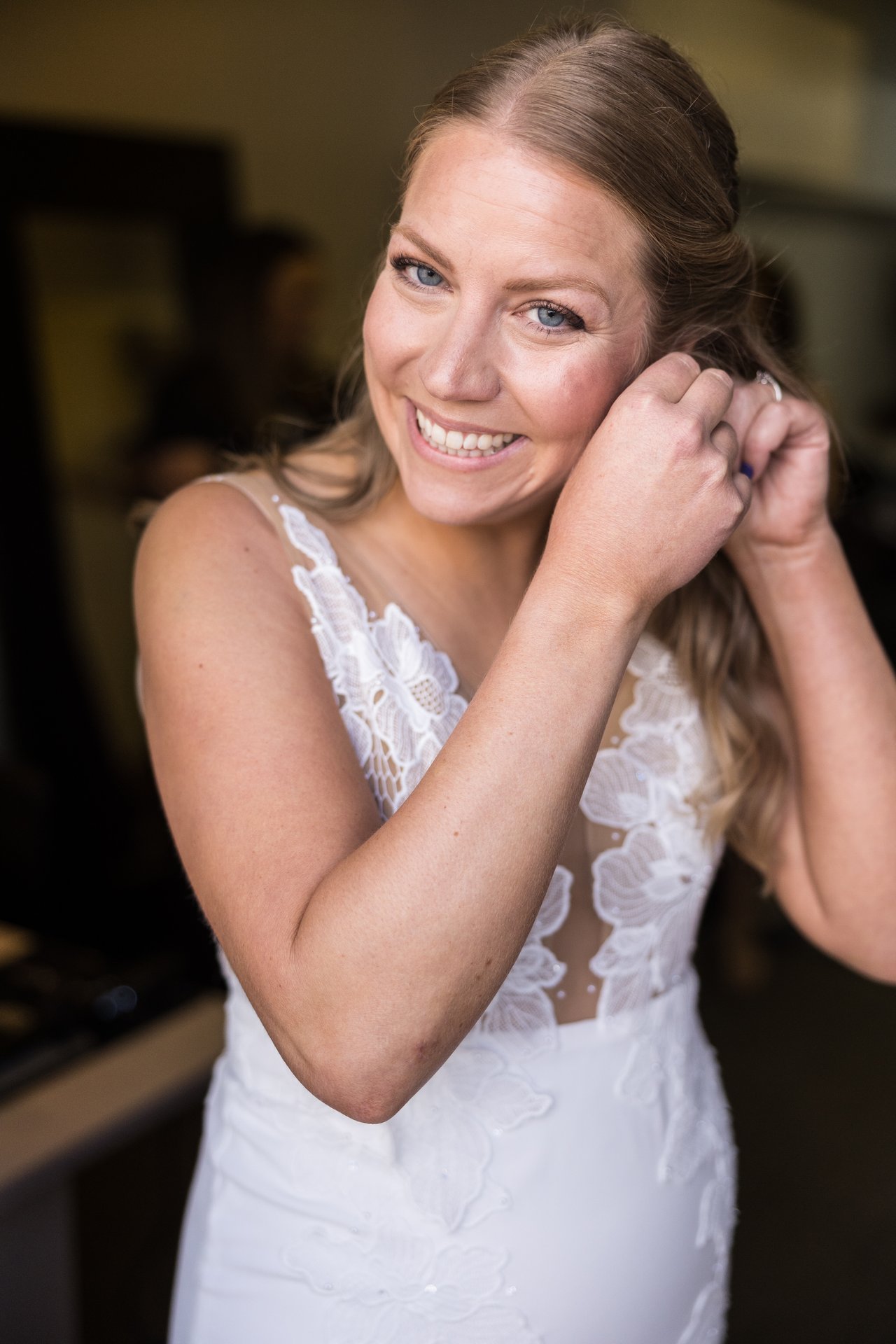 Ali smiles as she puts on her earrings