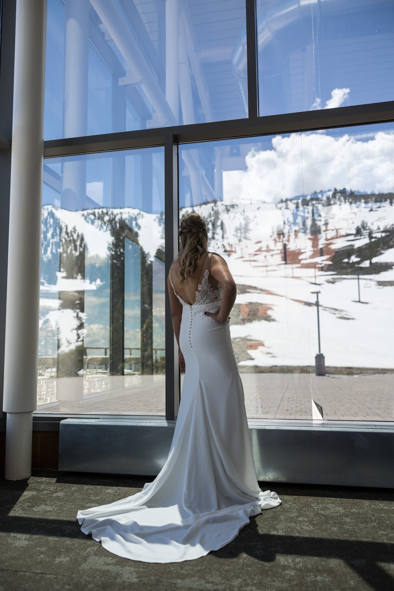 Ali at a tall window with snow outside
