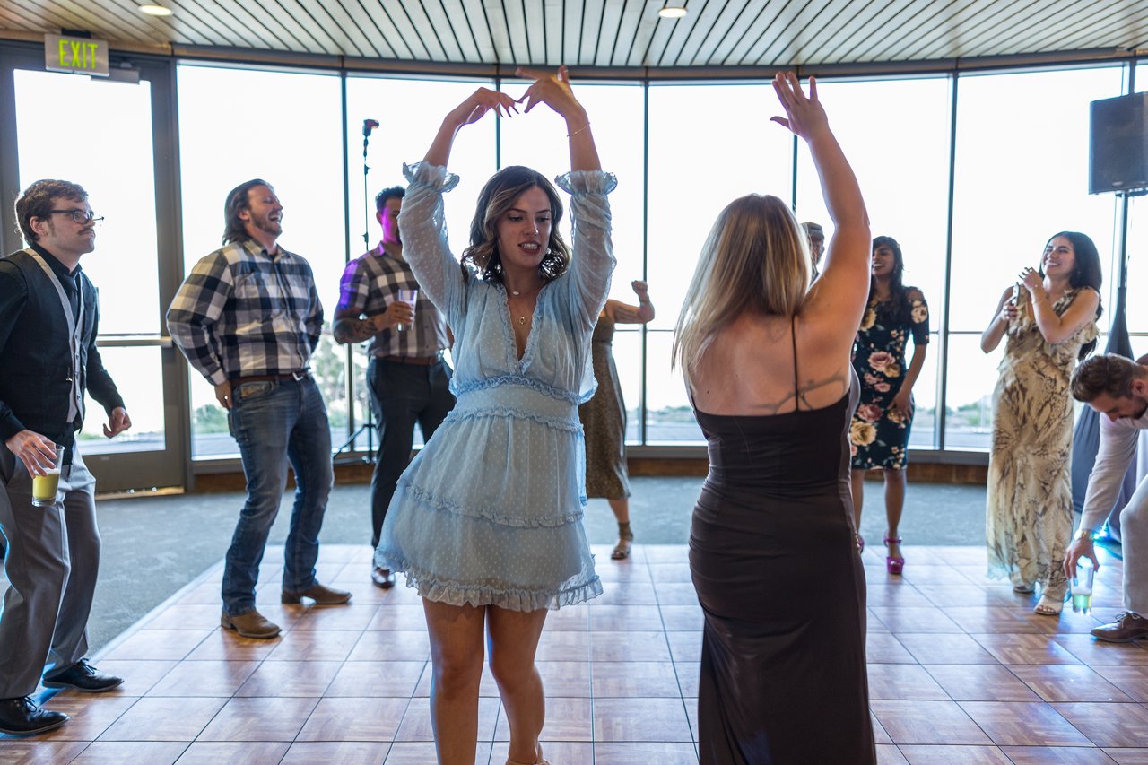 Friends with their arms up on the dance floor
