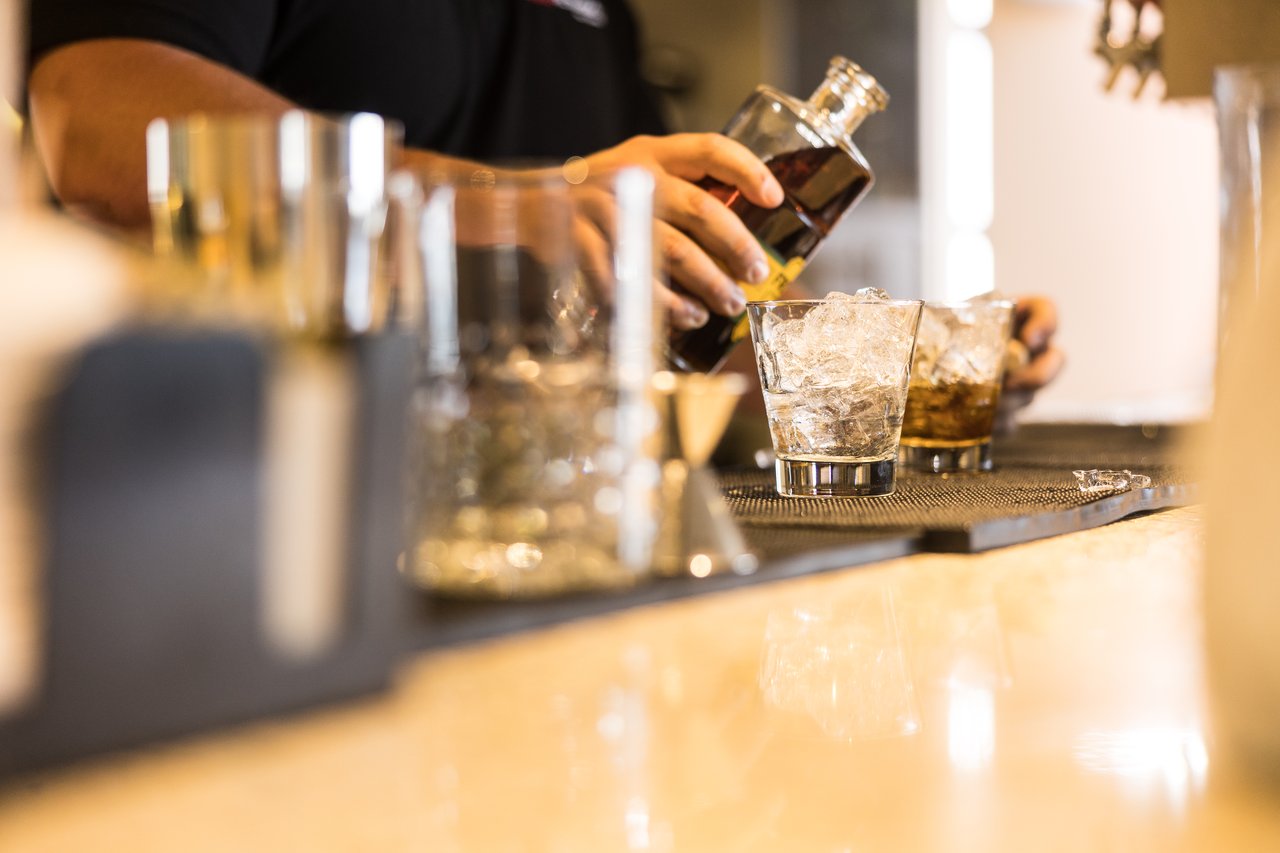 A bartender pours a drink