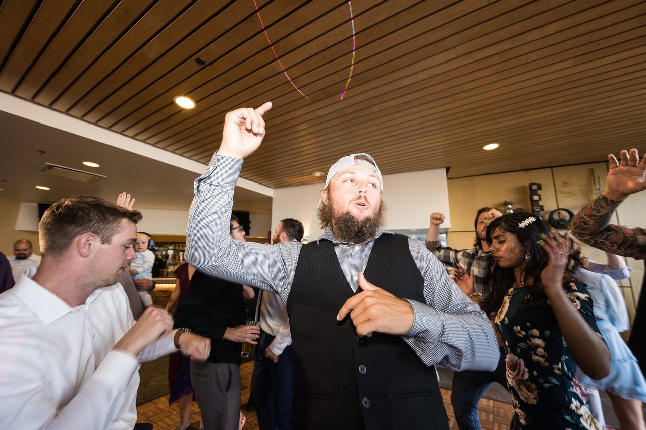 A guest throws his arm up on the dance floor