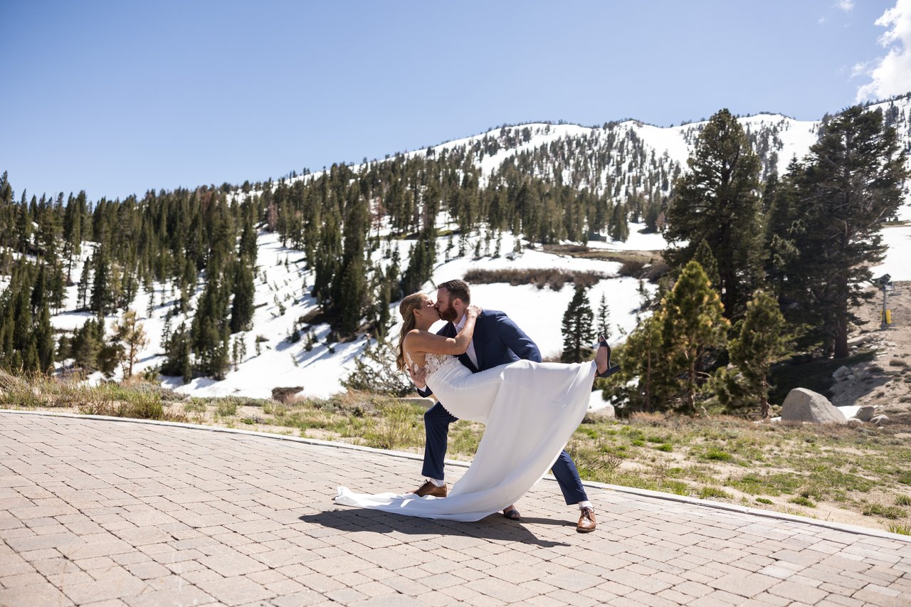 Robert dips Ali for a kiss with the snowy slope behind them