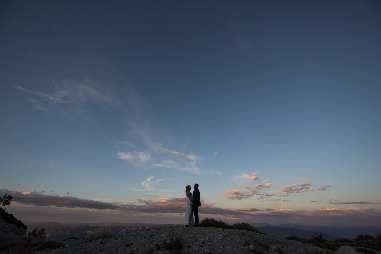 Ali and Robert silhouetted on the summit at dusk
