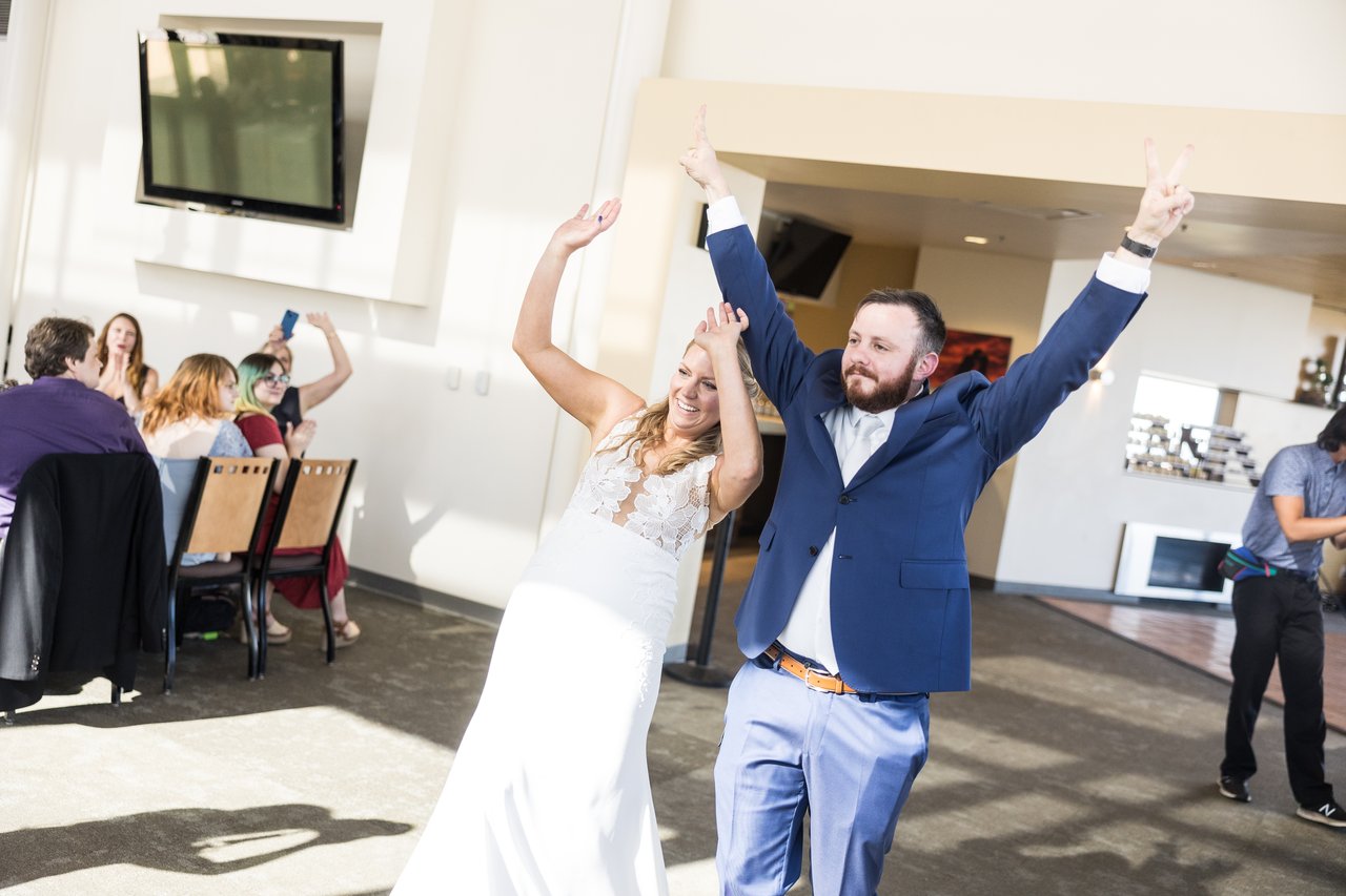 Ali and Robert dance in with their arms up