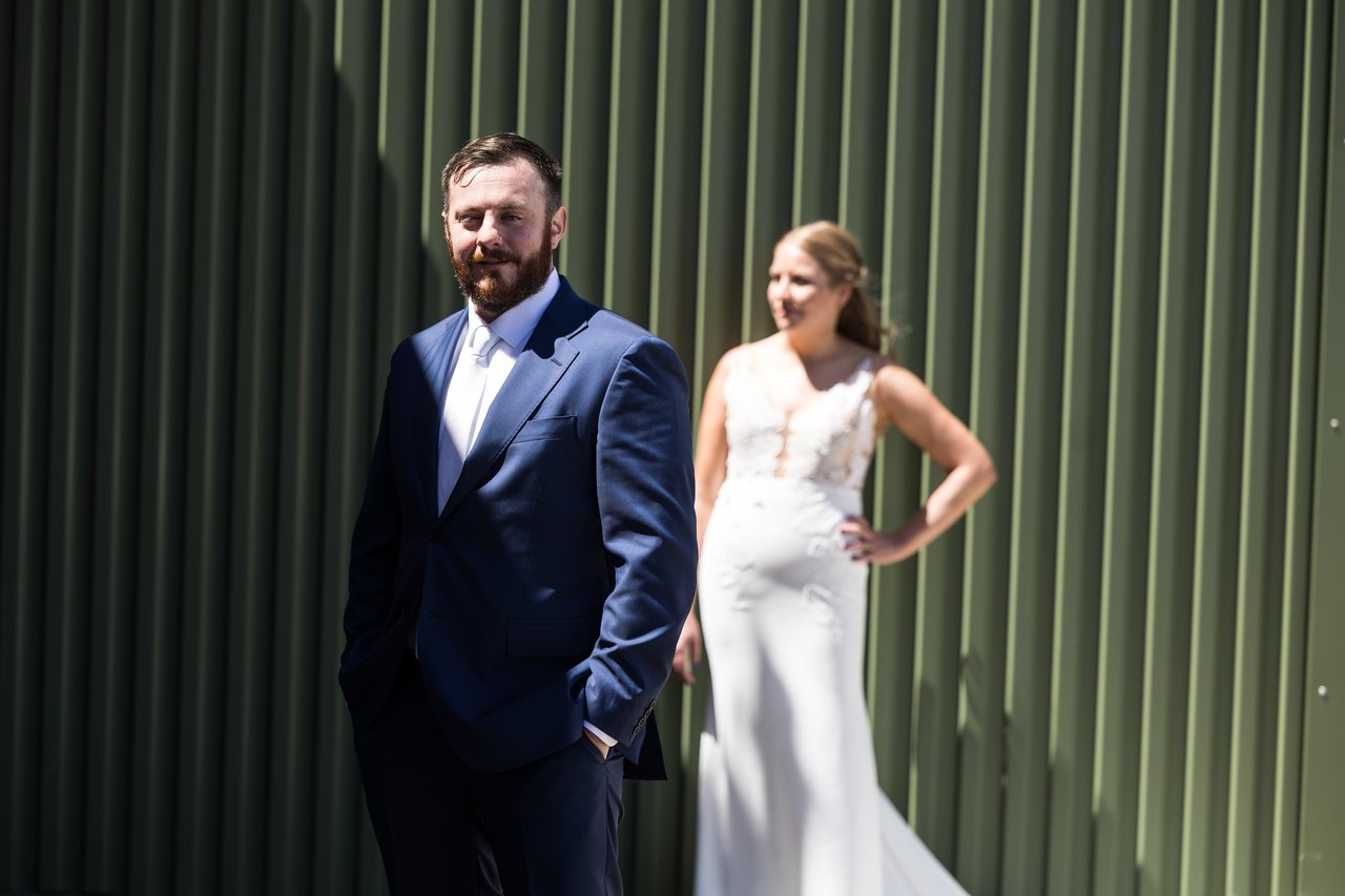 Ali and Robert by a green corrugated wall