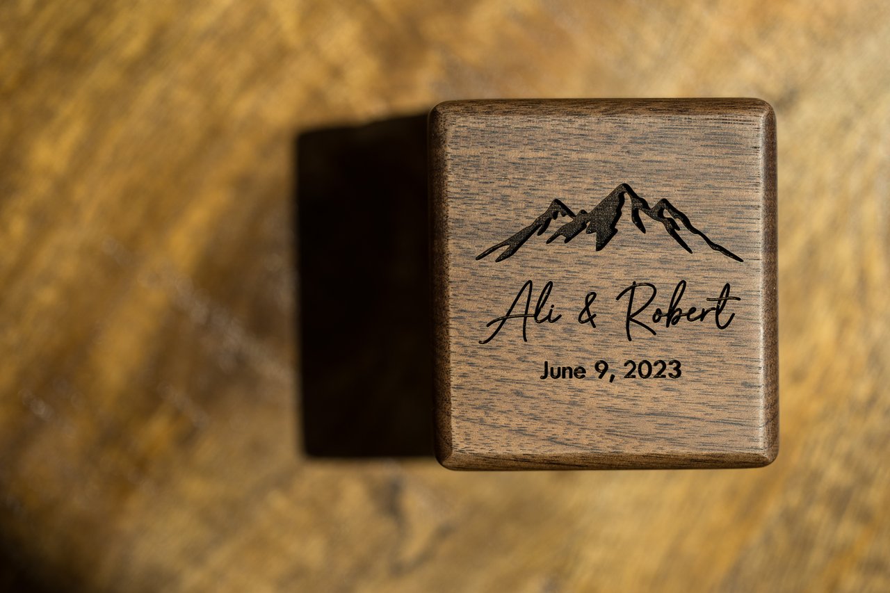A wooden ring box engraved with Ali and Robert and their wedding date