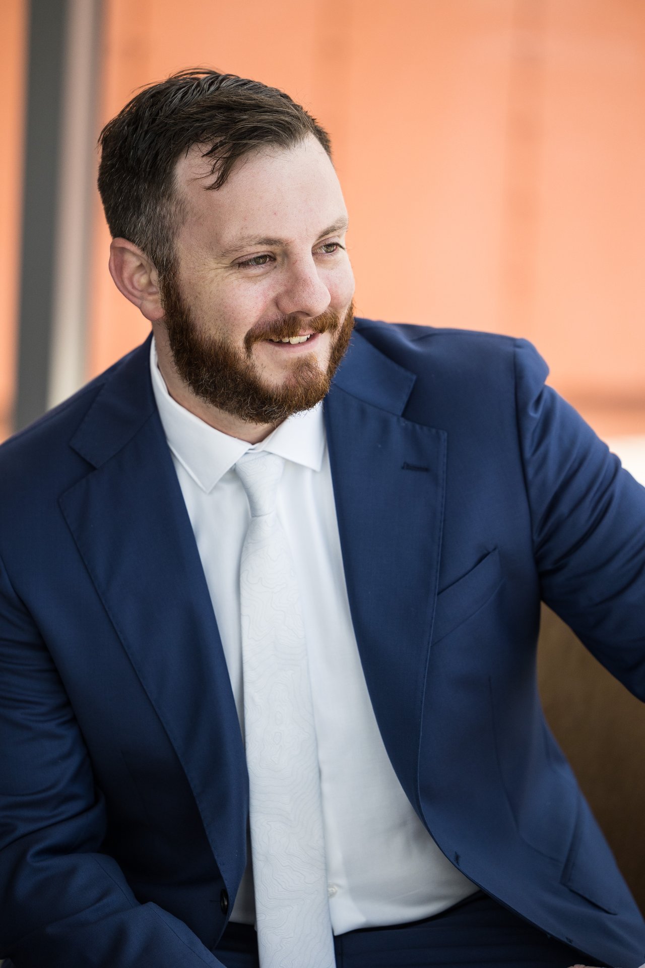 Robert smiling against an orange wall