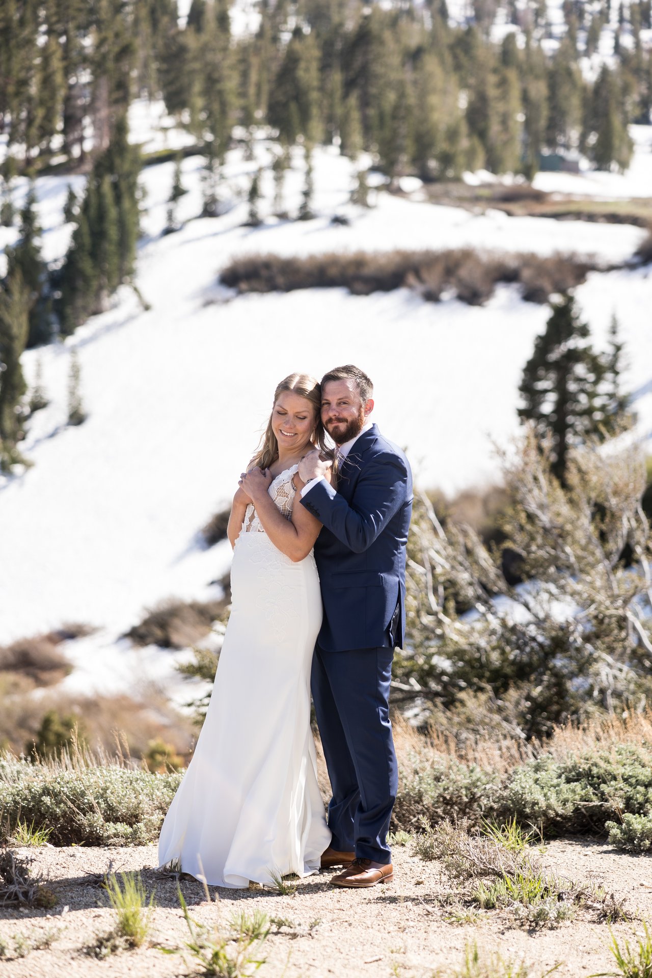Ali and Robert embrace with the snowy slope behind them