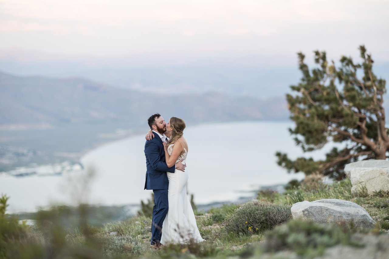 A kiss on the ridge with the lake behind them