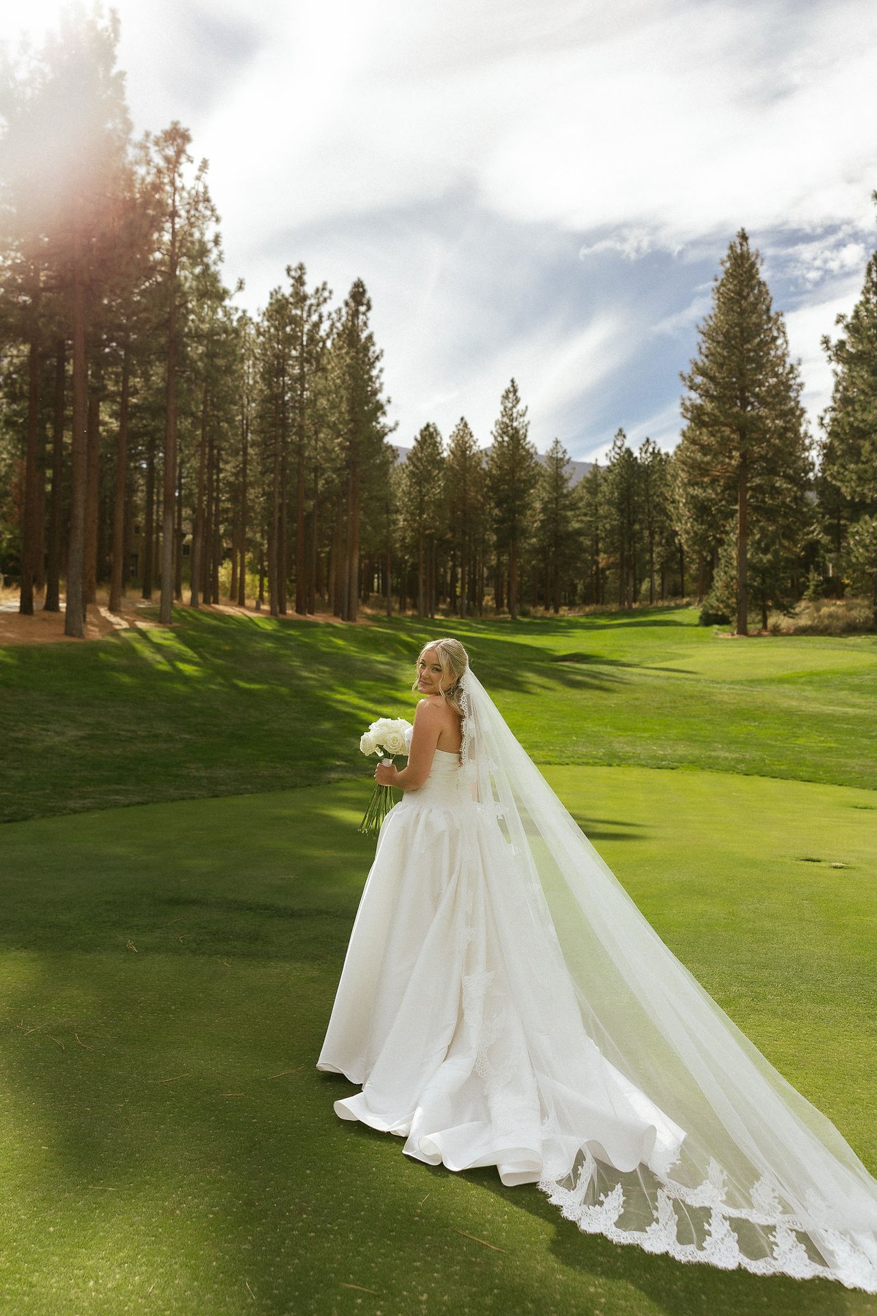 Ally's veil lifts in the breeze among the pines