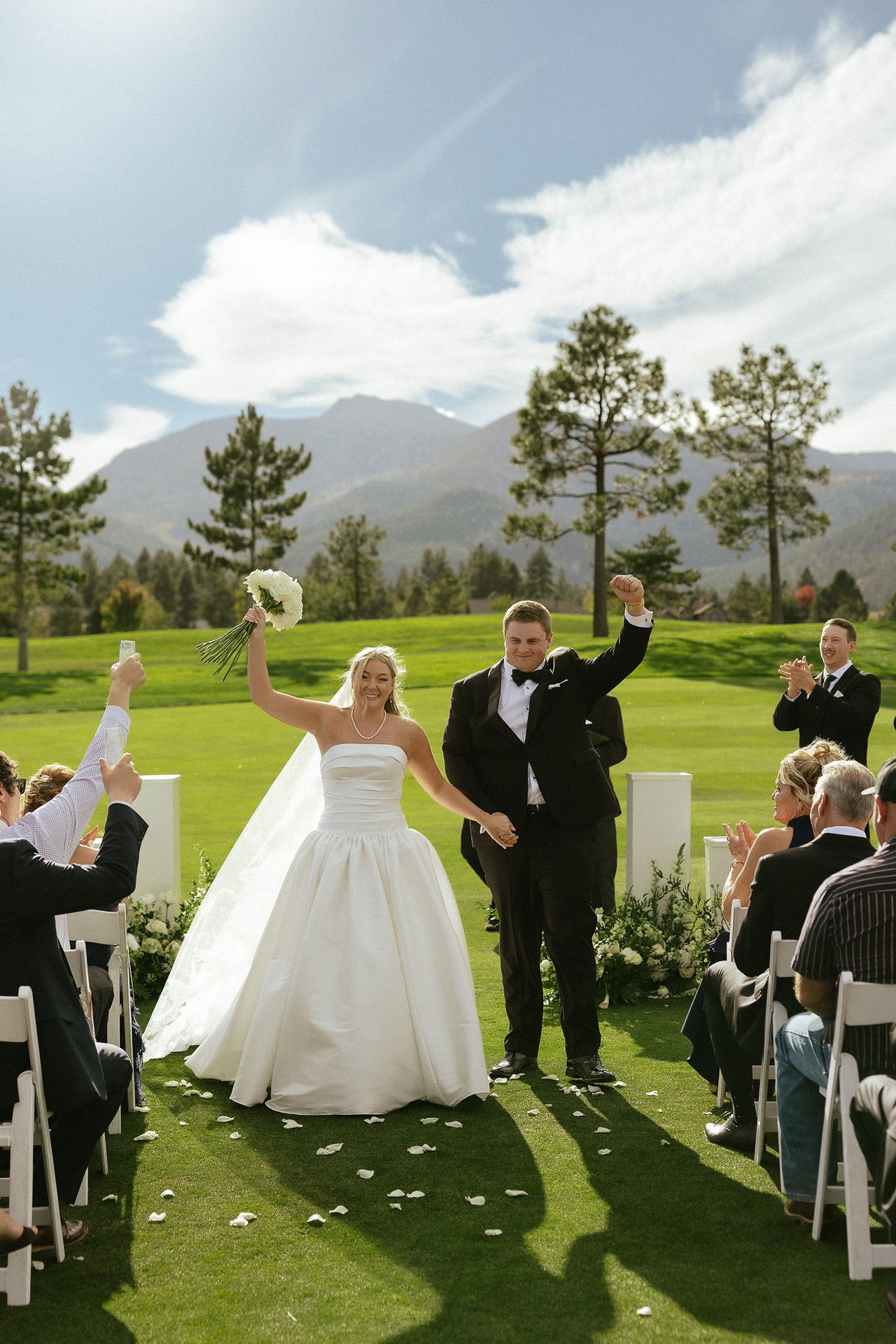 Ally raises her roses and Drew pumps his fist as they walk back up the aisle