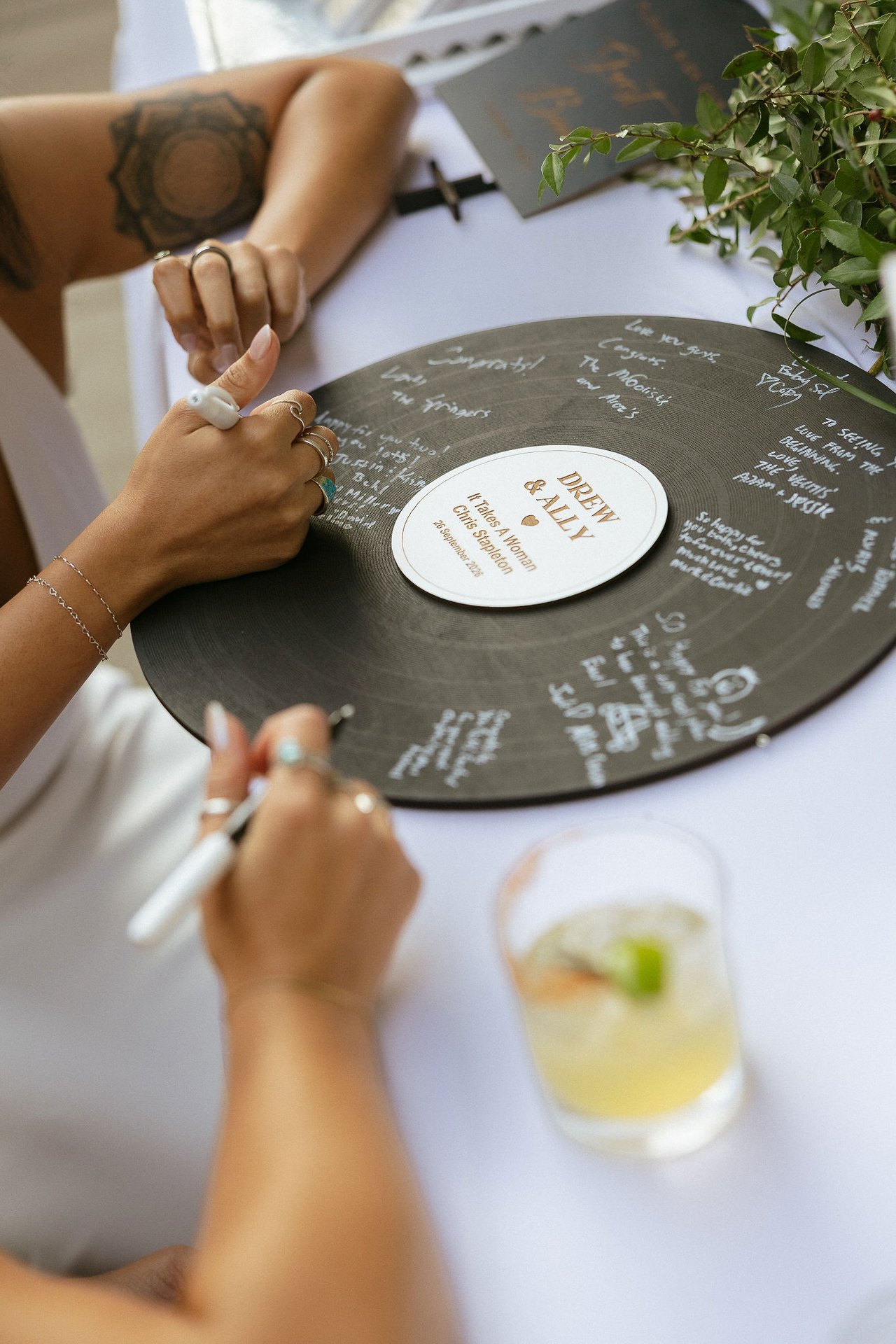 A guest signs the vinyl record guest book
