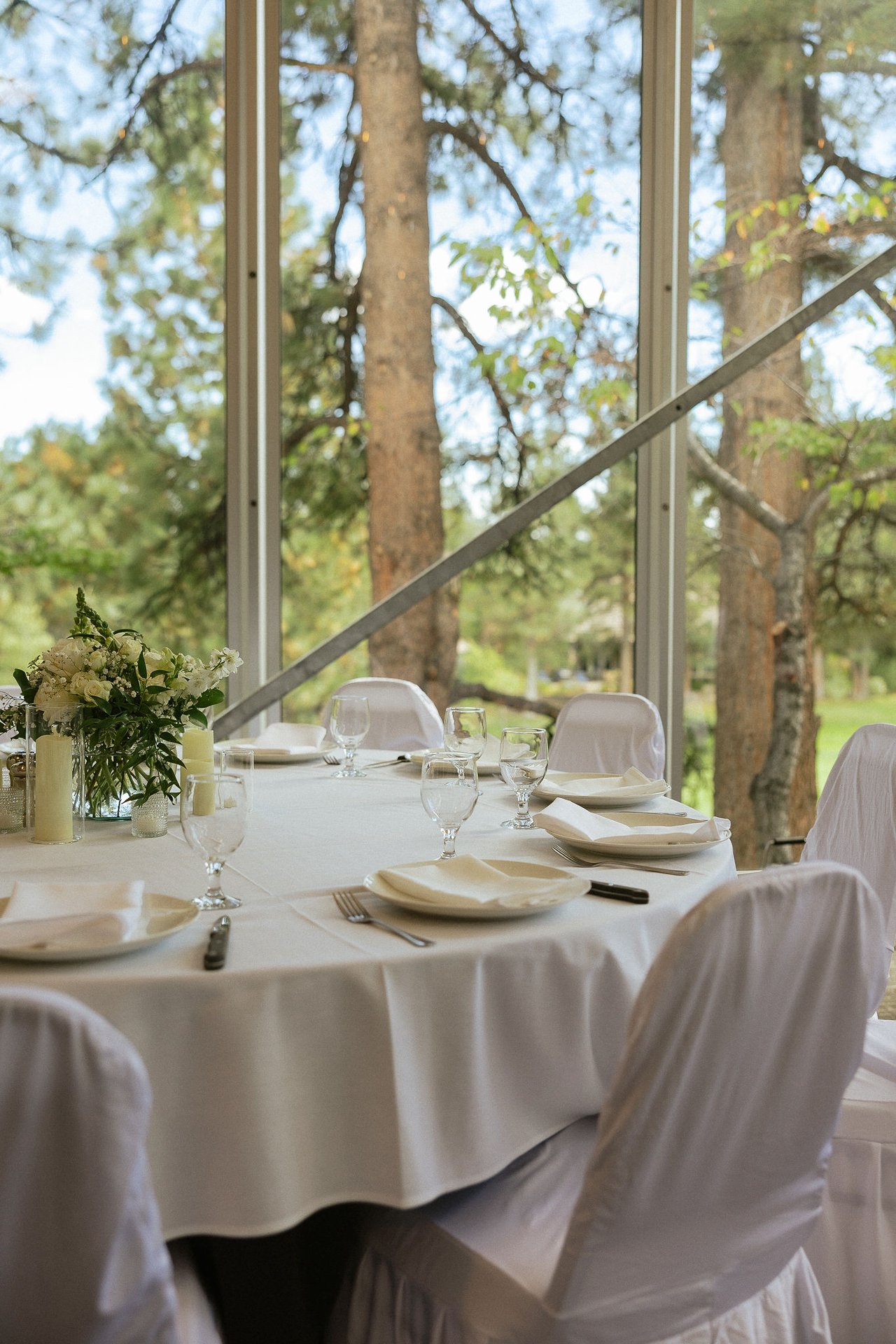The tables set in the tent, with the pines filling the windows behind them