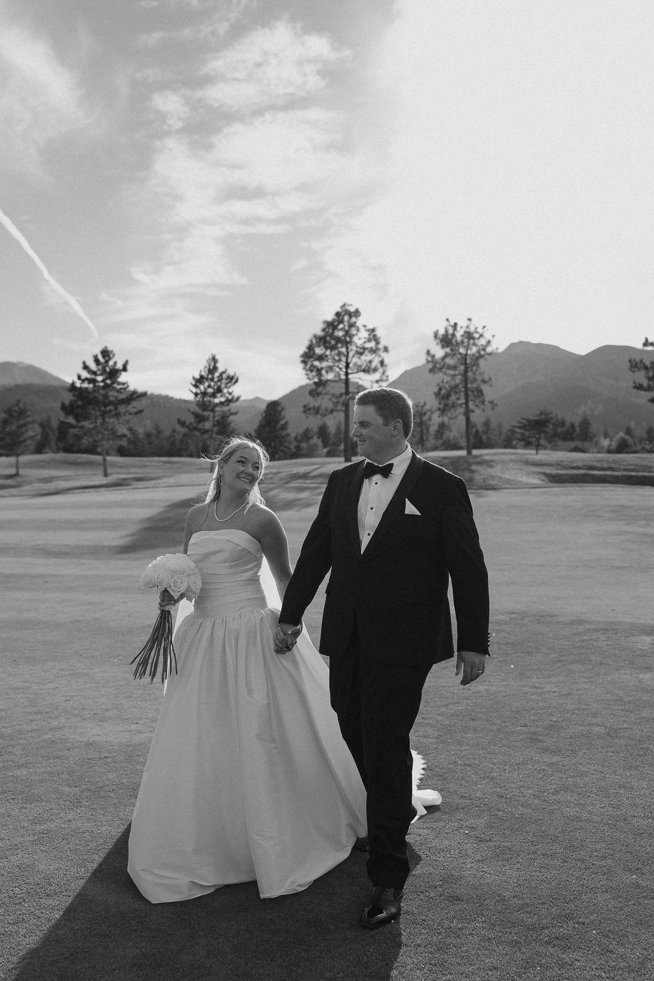 Ally and Drew walk hand in hand, in black and white