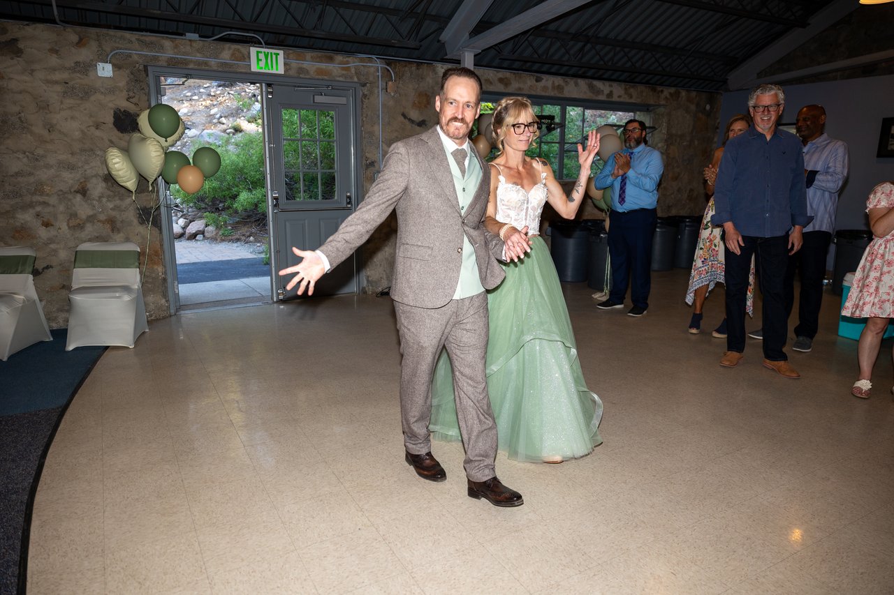 Justin throws his arms wide as he and Amy enter the reception