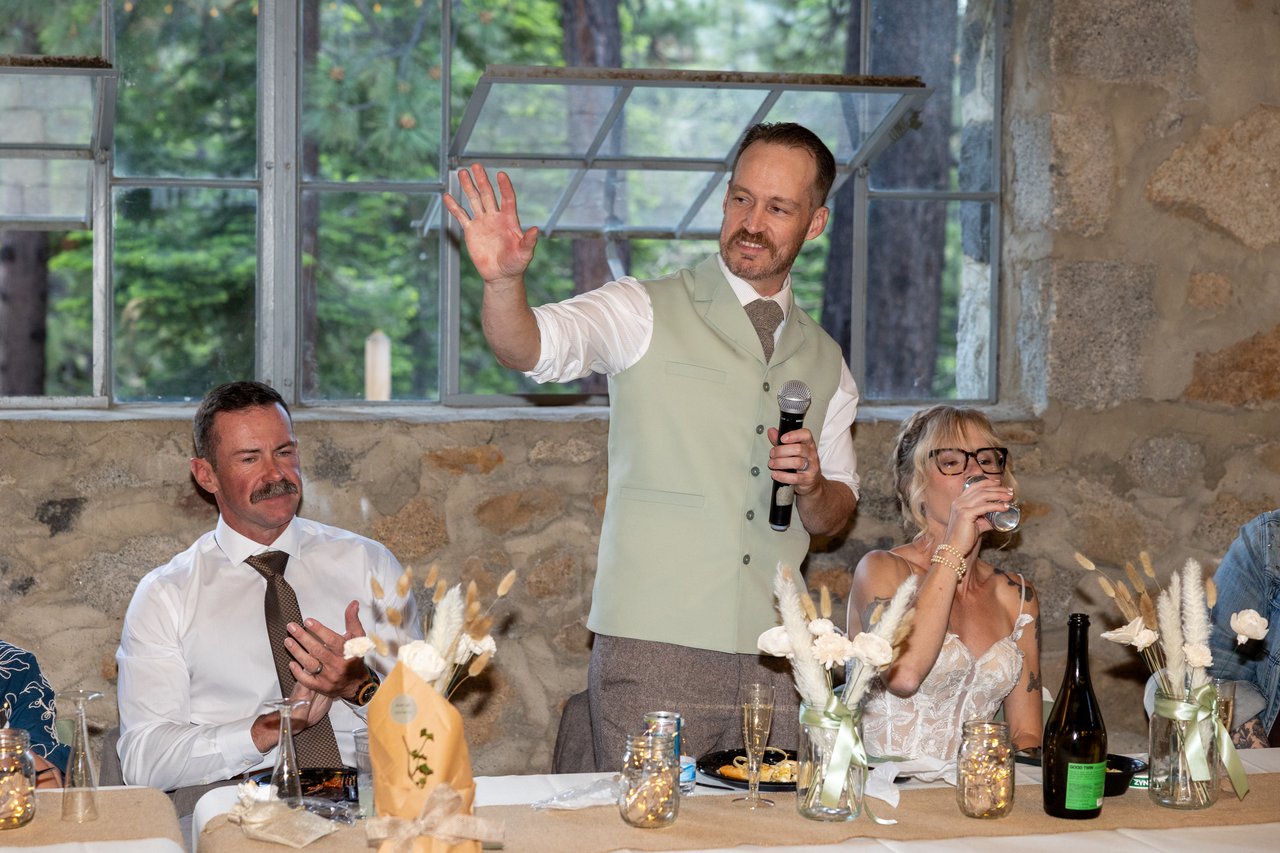 Justin raises his hand as he gives a toast at the head table