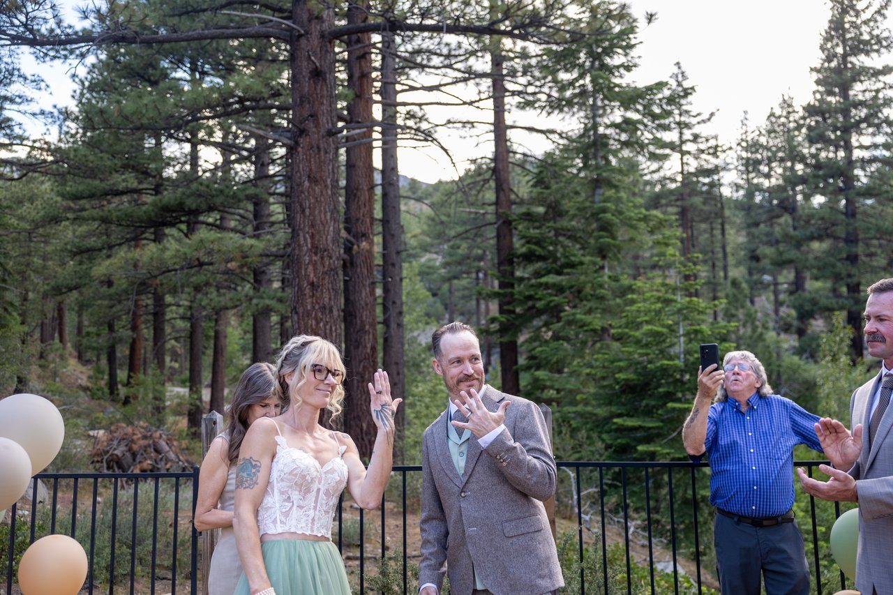 Amy and Justin laugh with the officiant during the ceremony