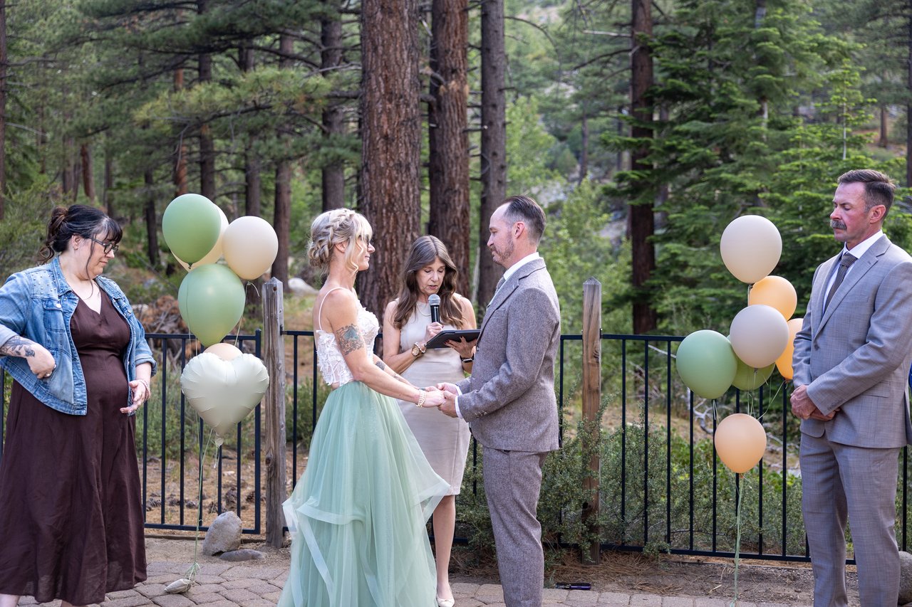 The officiant speaks to Amy and Justin with balloons on each side
