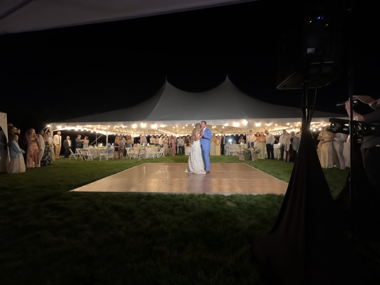 Anabella dances with her father in his sky blue suit as guests watch from the tent