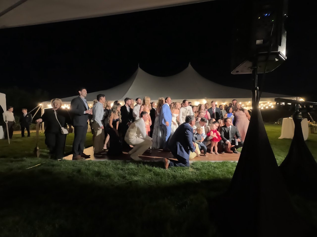 Friends and family pack the dance floor for a group photo at night