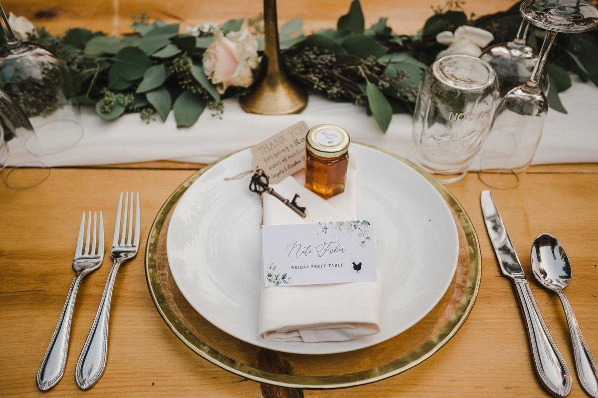 A place setting with a honey jar, a key bottle opener and a bridal party table card, photo by Composing Reality Photography