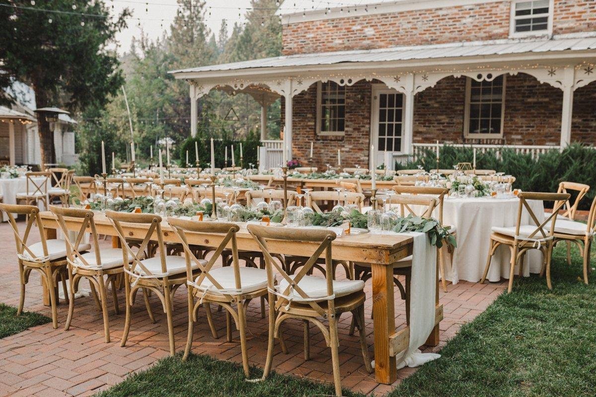 Reception tables with cross back chairs set on the brick patio by the brick house, photo by Composing Reality Photography